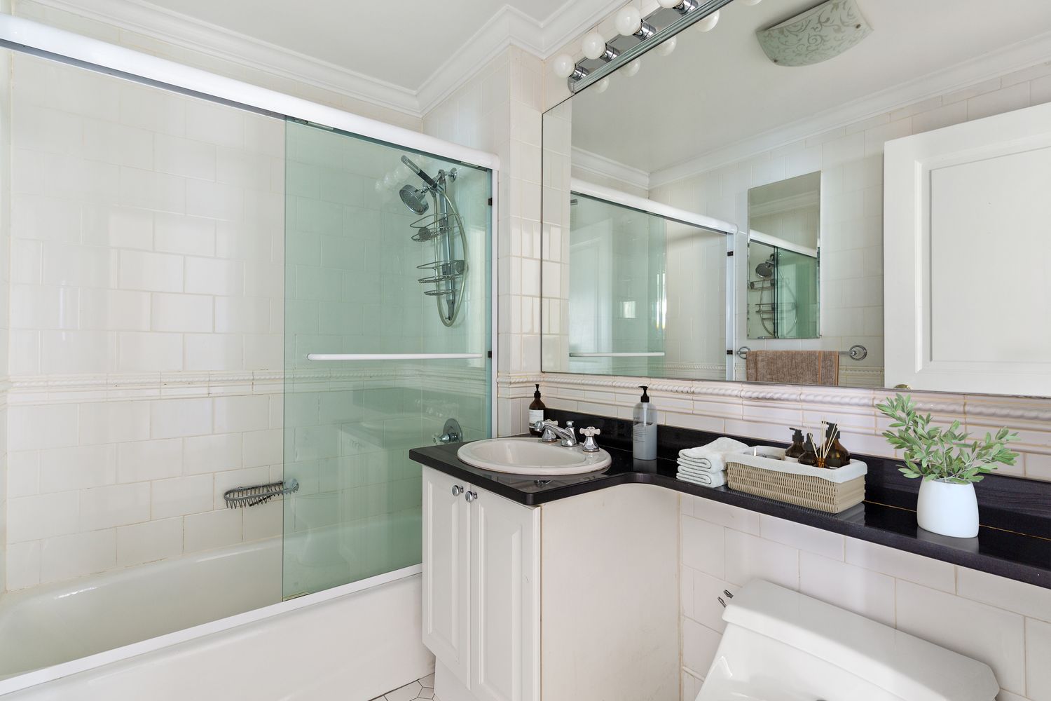 400 East 90th Street, Unit 7D Manhattan, NY 10128 - Photo 5 of 8 a bathroom with a granite countertop sink a shower and a mirror
