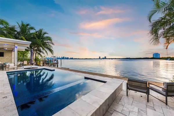 a view of swimming pool with outdoor seating and lake