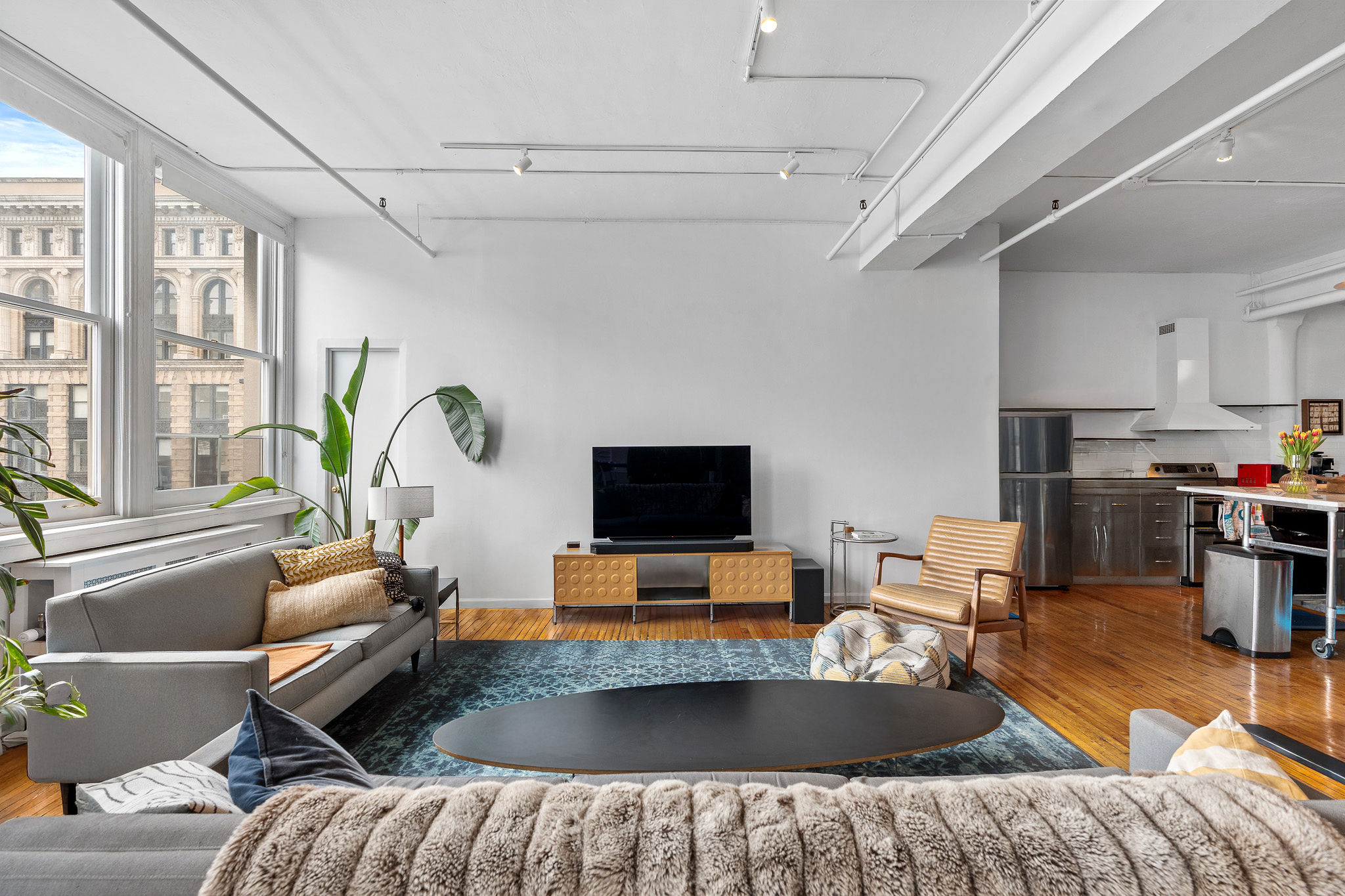 565 Broadway, Unit 8W Manhattan, NY 10012 - Photo 10 of 23 a living room with furniture and a flat screen tv
