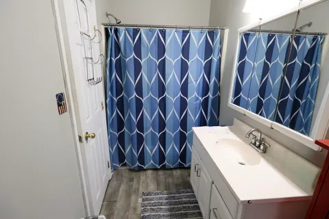 a bathroom with a sink a toilet a mirror and shower