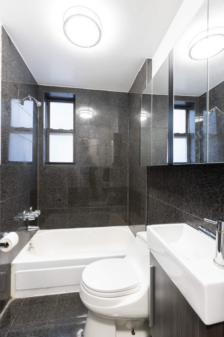119 East 96th Street, Unit 21 Manhattan, NY 10128 - Photo 5 of 5 a bathroom with a sink a toilet a mirror and bathtub