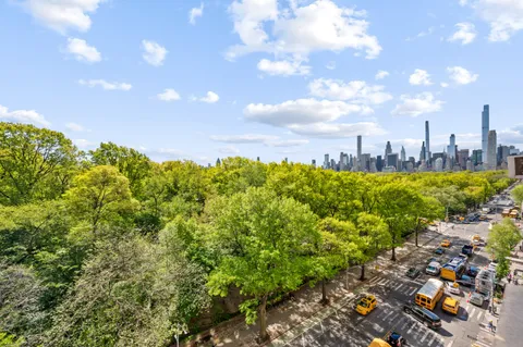 a view of a city with lush green forest
