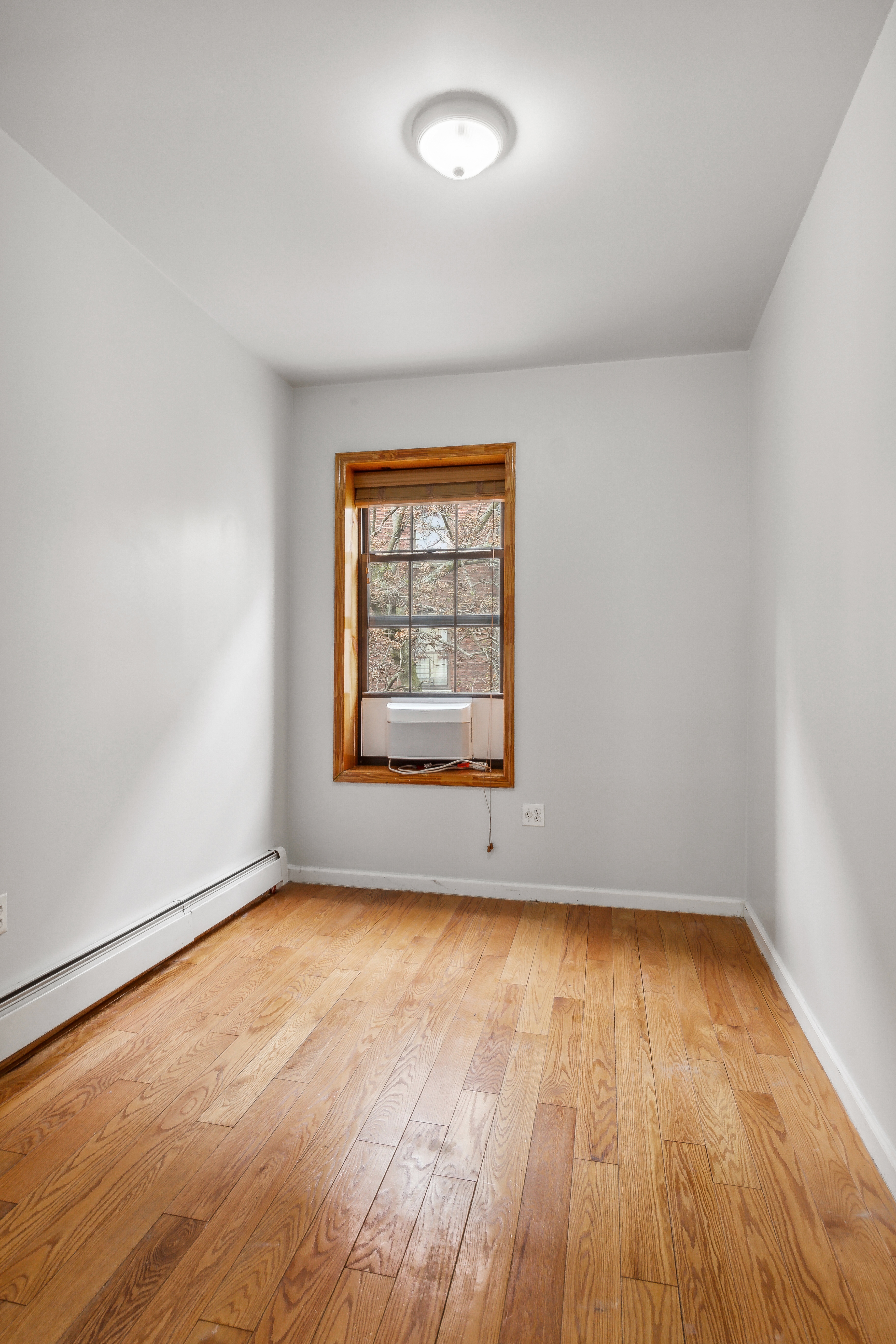 530 West 175th Street, Unit 2 Manhattan, NY 10033 - Photo 9 of 12 an empty room with wooden floor and windows