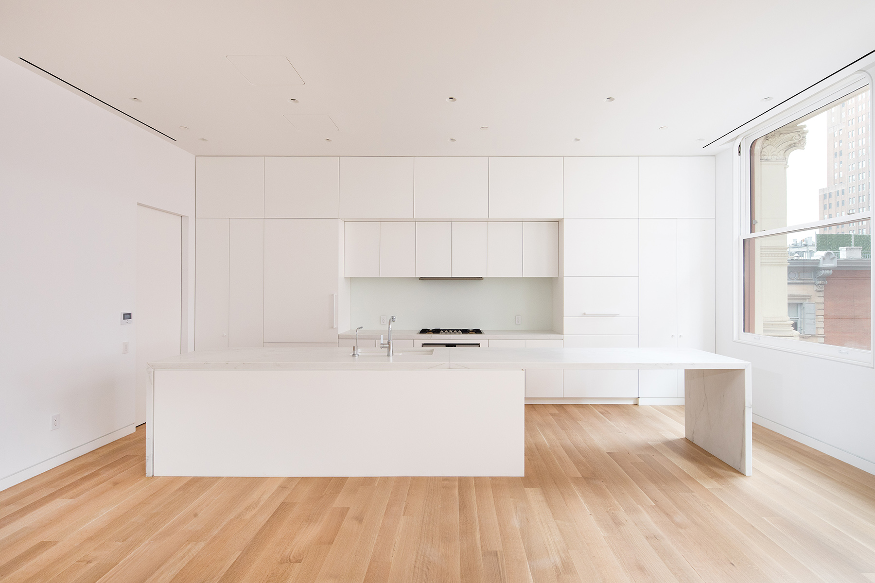 67-69 Franklin Street, Unit 2B Manhattan, NY 10013 - Photo 3 of 16 a kitchen with stainless steel appliances a large counter top and a wooden floor