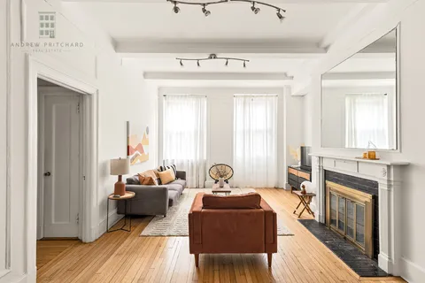 a living room with furniture a fireplace and a wooden floor