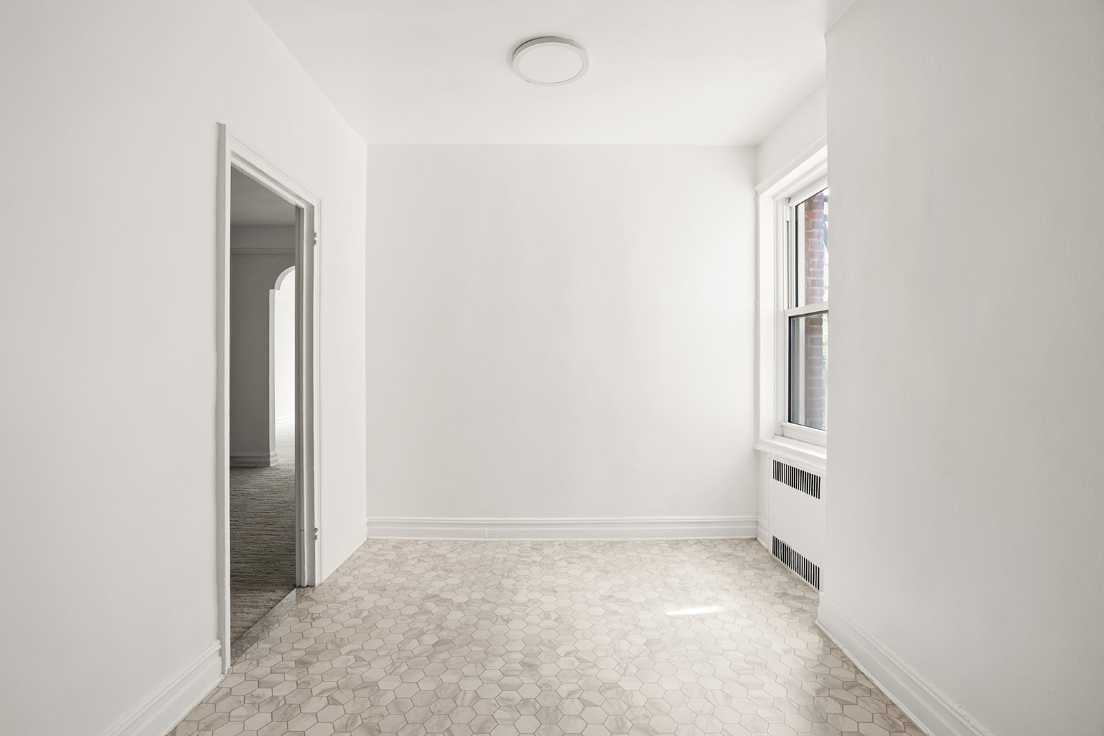 72-17 34th Avenue, Unit 4J Queens, NY 11372 - Photo 4 of 14 an empty room with a natural light