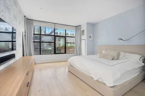 a bedroom with a large bed and a large window