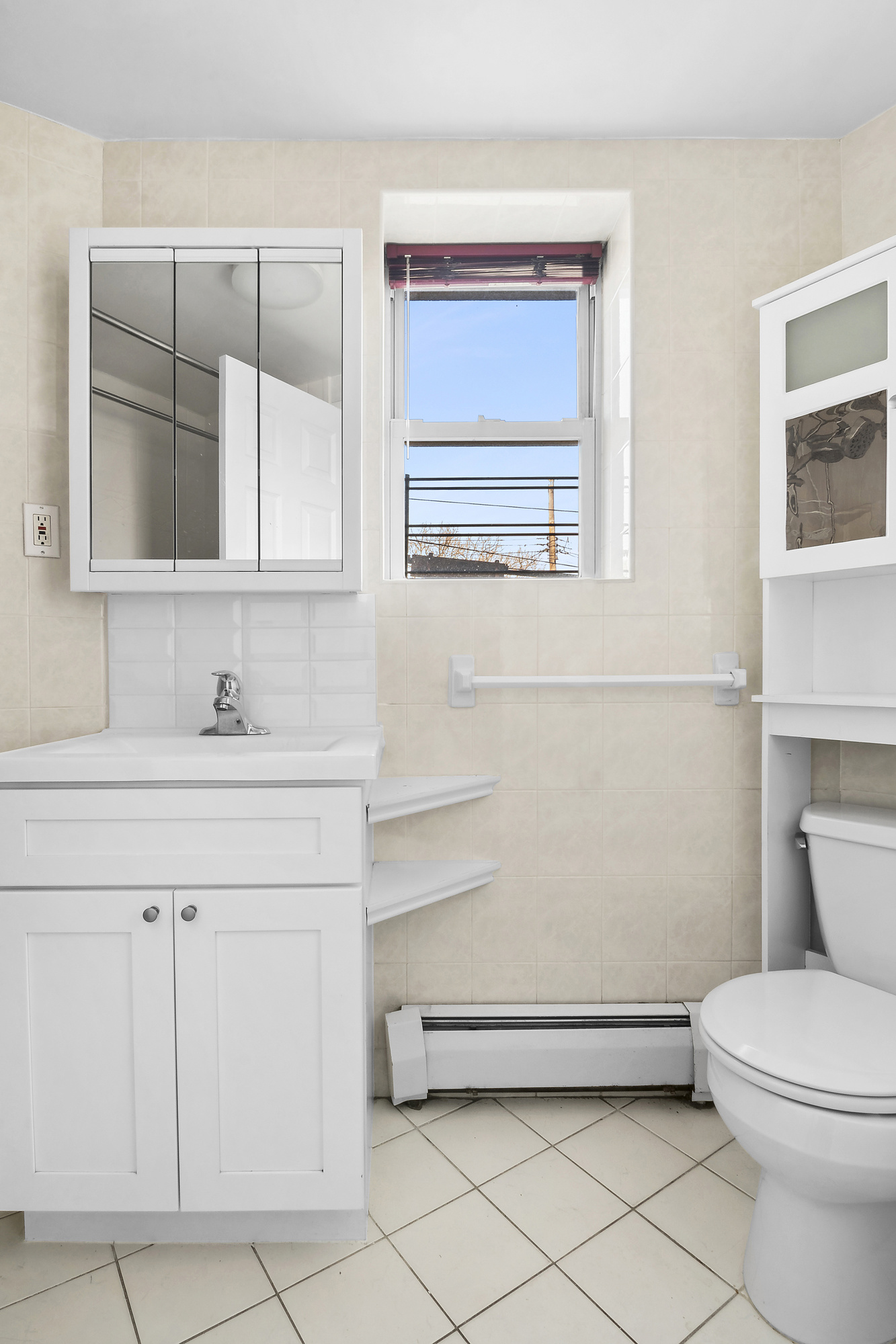 21-08 Butler Avenue, Unit J2 Queens, NY 11385 - Photo 7 of 14 a bathroom with a sink a toilet and mirror