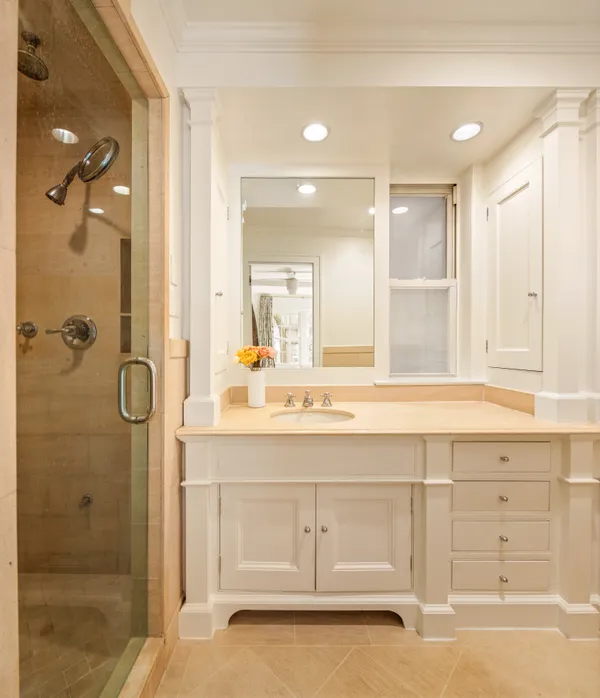 a bathroom with a sink shower and a mirror