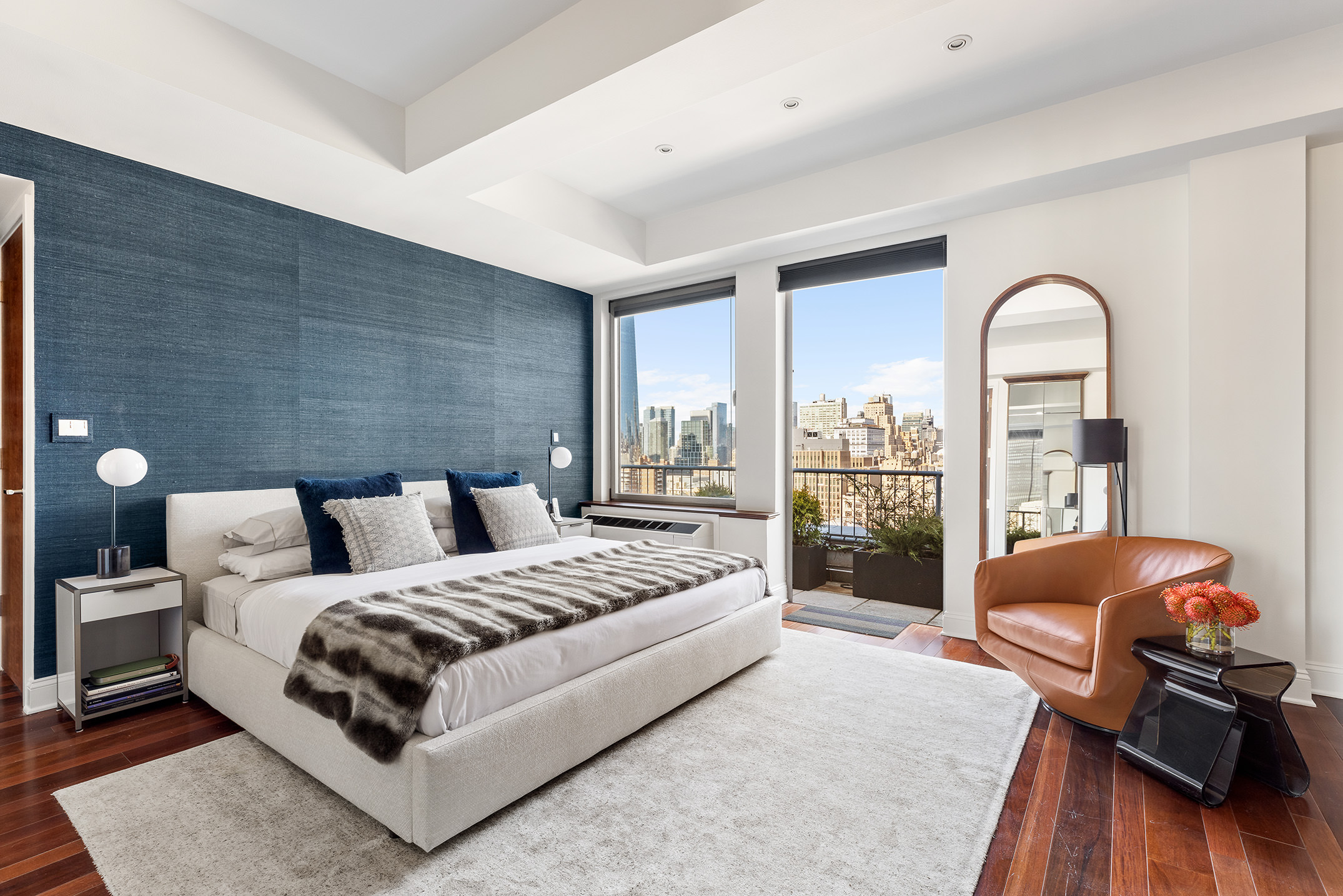 252 7th Avenue, Unit PHG Manhattan, NY 10001 - Photo 13 of 27 a bedroom with a bed couch and wooden floor