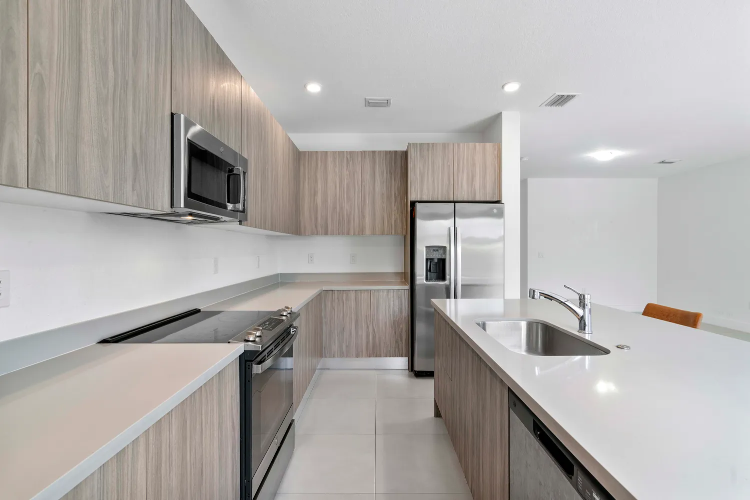a kitchen with a sink a counter top space stainless steel appliances and cabinets