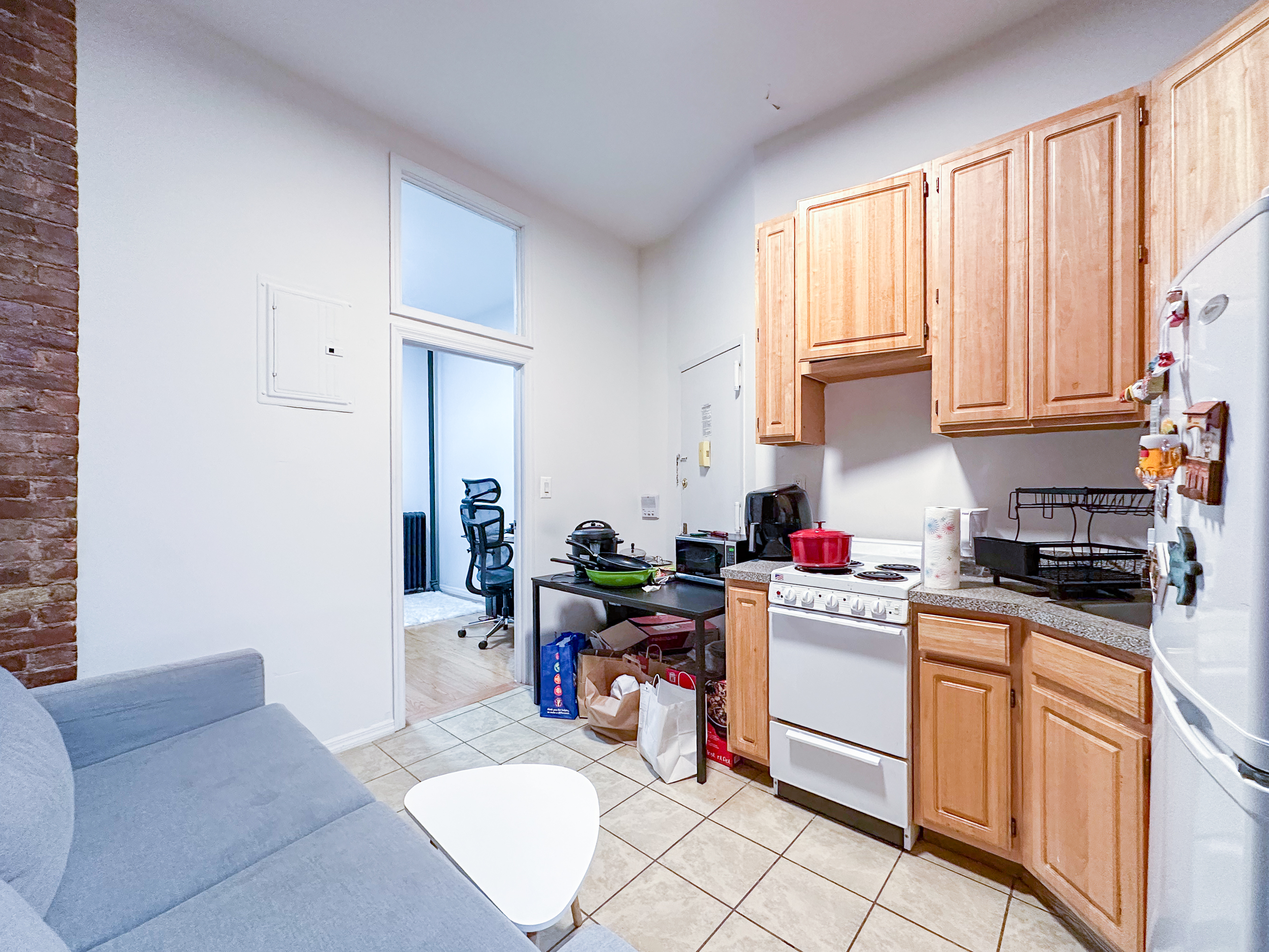 213 East 5th Street, Unit 1 Manhattan, NY 10003 - Photo 9 of 18 a kitchen with stainless steel appliances granite countertop a stove a sink dishwasher and cabinets with wooden floor