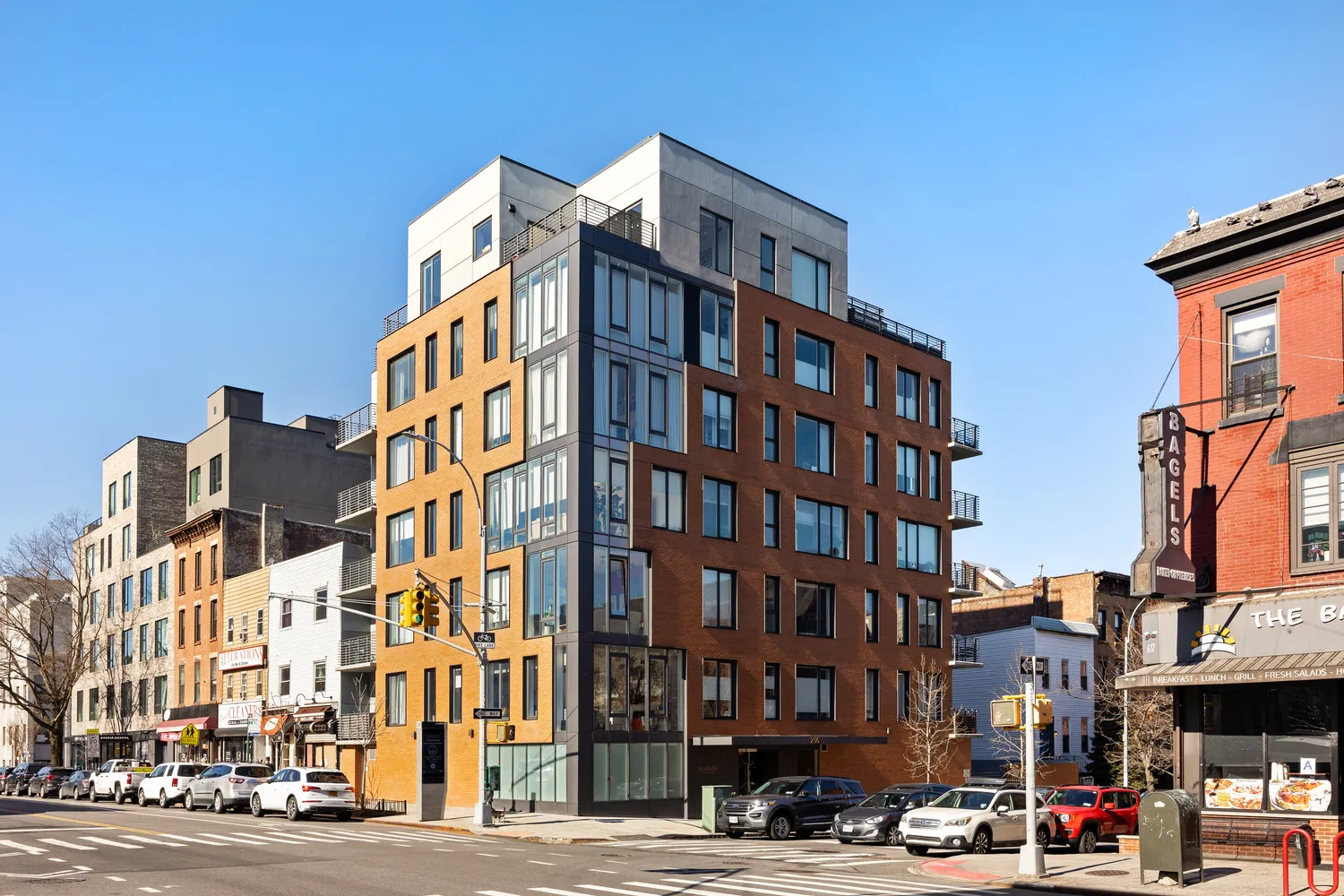 a front view of a building with lot of cars and trees