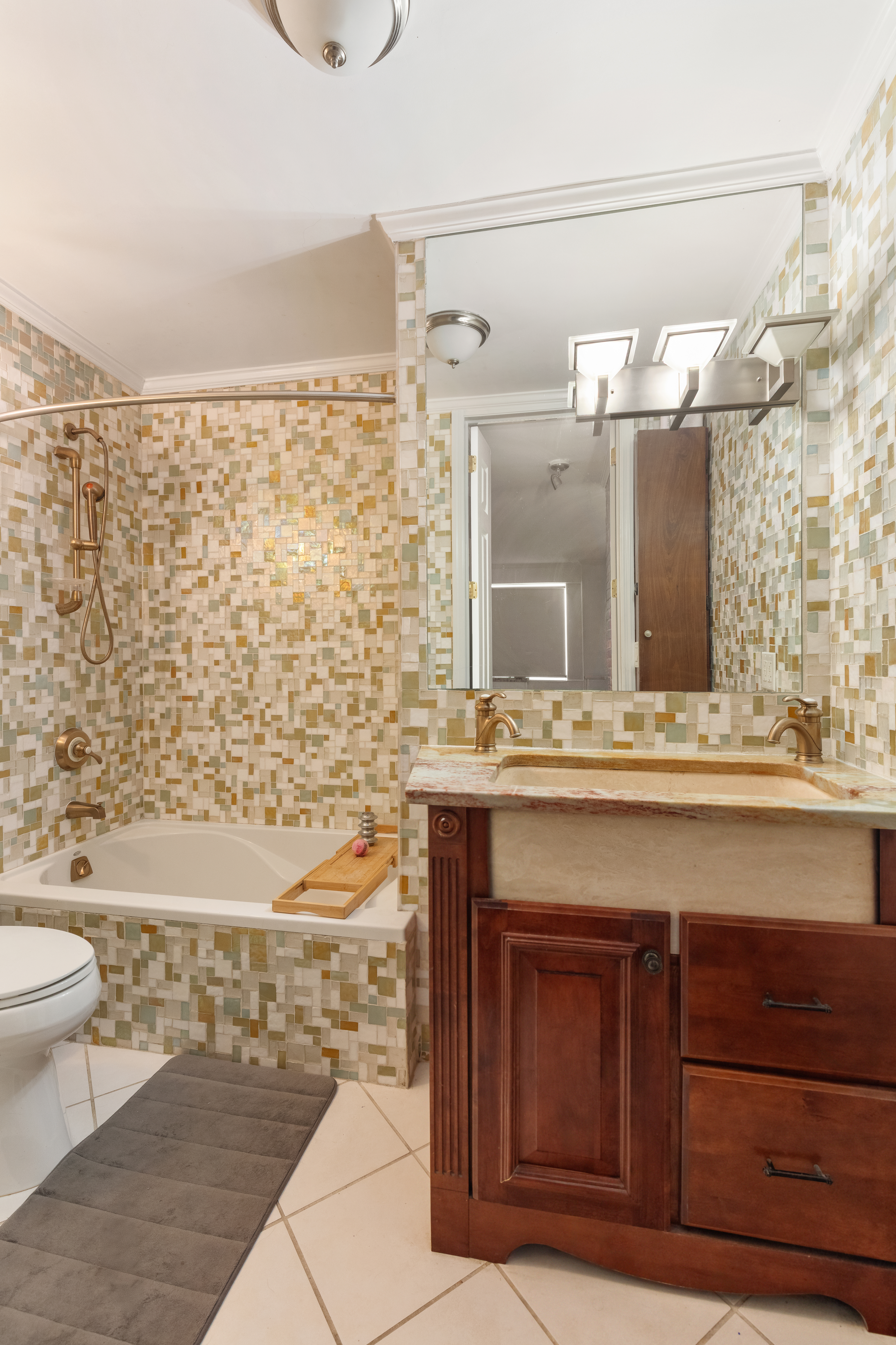 400 East 54th Street, Unit 21CDE Manhattan, NY 10022 - Photo 8 of 10 a bathroom with a sink a toilet and shower
