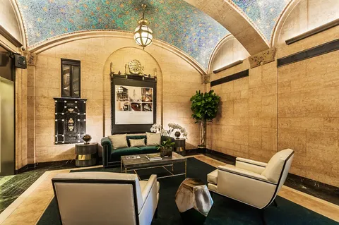 a living room with furniture a potted plant and a large window