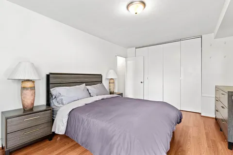 a bedroom with a bed and painting on the wall