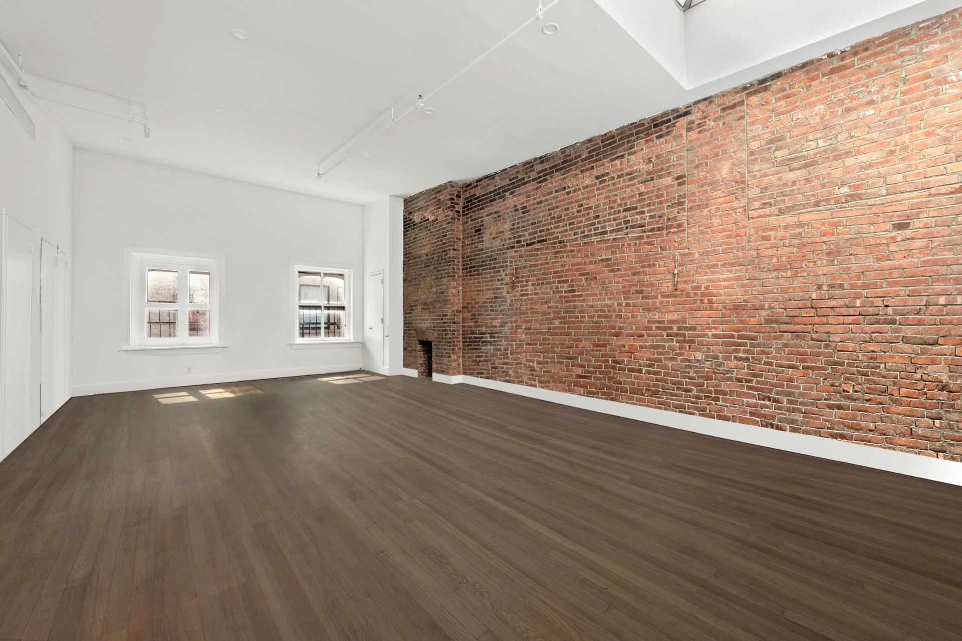 99 Spring Street, Unit PH Manhattan, NY 10012 - Photo 5 of 23 a view of an empty room with wooden floor and a window