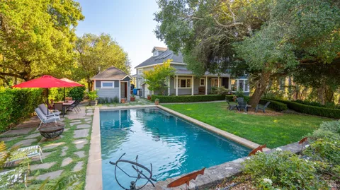 a view of a house with swimming pool and a yard