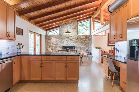 a kitchen with stainless steel appliances granite countertop a sink dishwasher cabinets and a stove with wooden floor