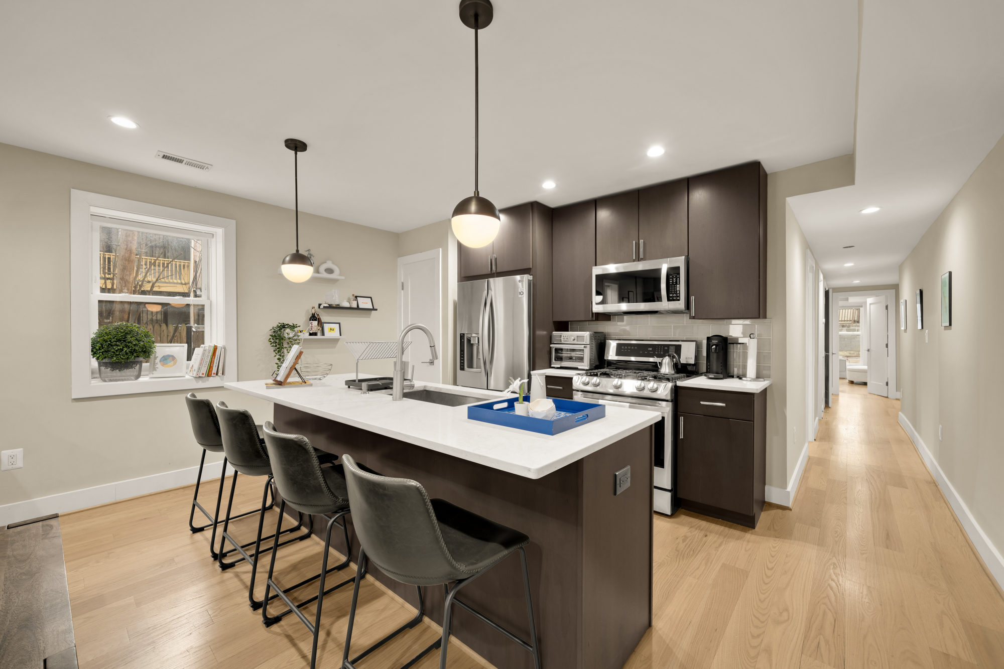 14 T Street Northeast, Unit 1 Washington, DC 20002 - Photo 15 of 39 a kitchen with stainless steel appliances granite countertop a stove top oven a sink dishwasher a dining table and chairs with wooden floor