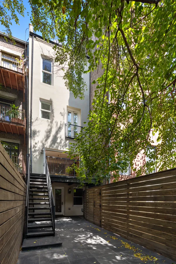 a view of a patio with two couches and deck with wooden floor and fence and a barbeque