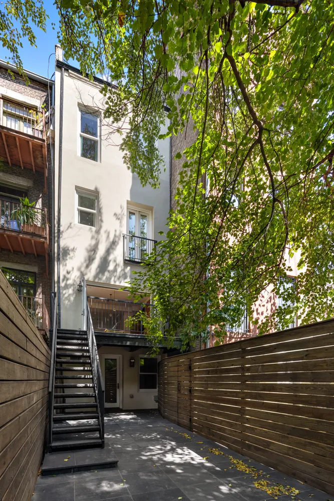 a view of a patio with two couches and deck with wooden floor and fence and a barbeque