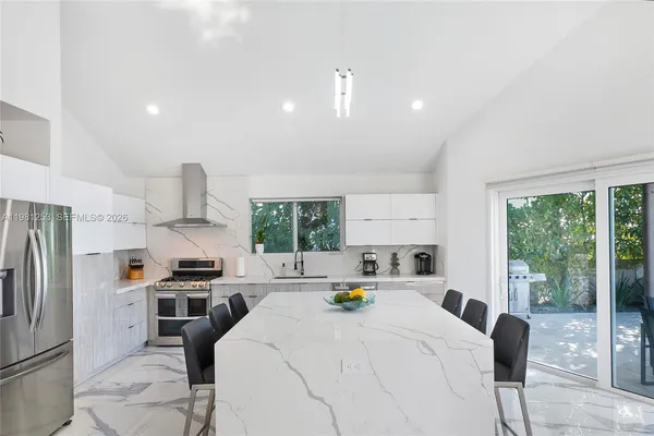 a kitchen with stainless steel appliances a refrigerator a sink a stove and a refrigerator