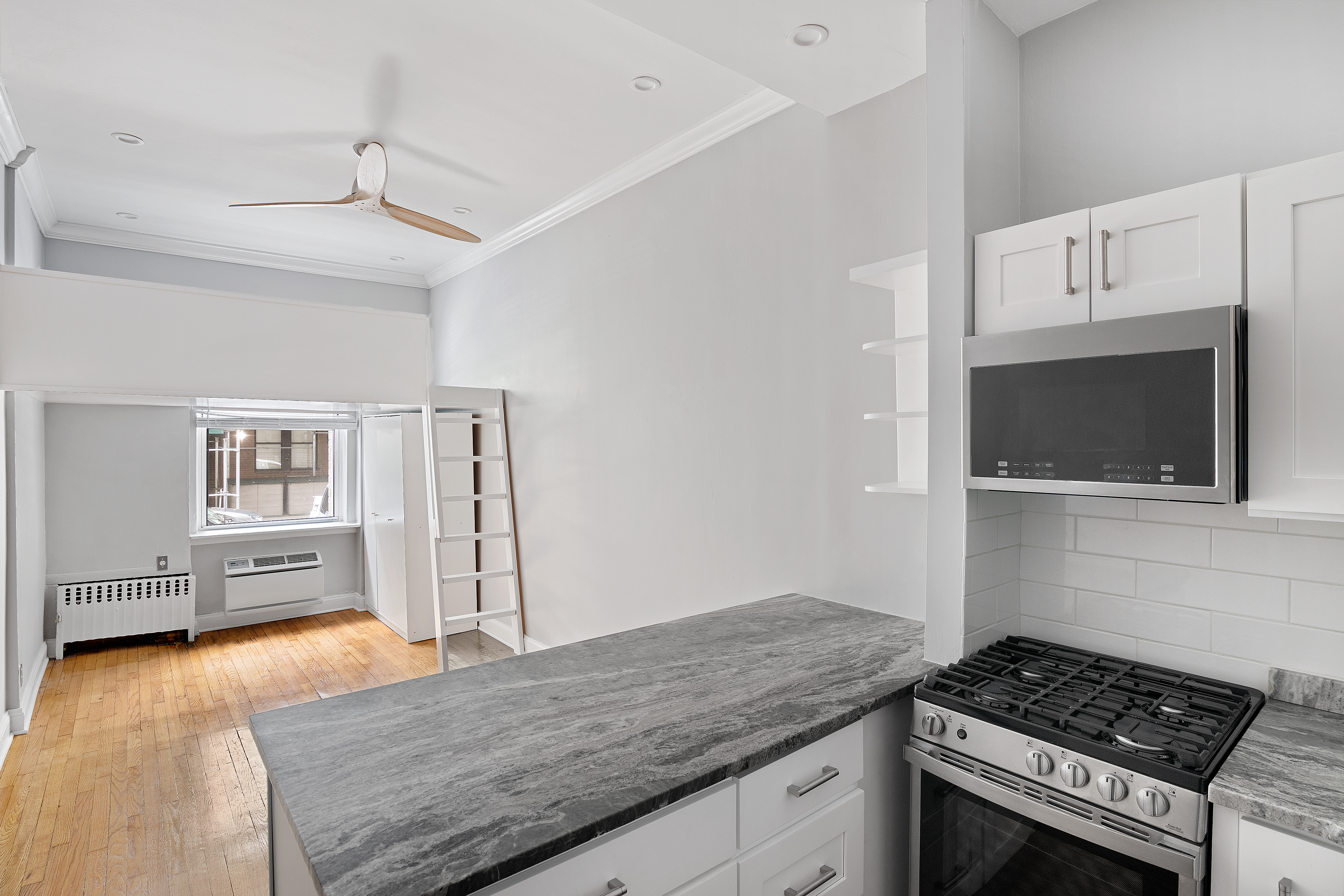 521 East 81st Street, Unit B Manhattan, NY 10028 - Photo 1 of 5 a kitchen with granite countertop a stove and a wooden floor