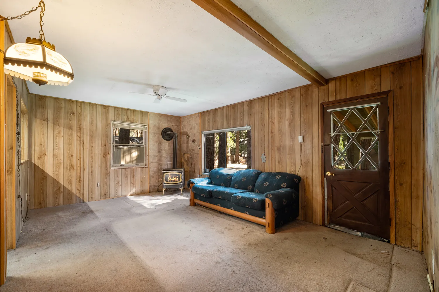 a living room with a couch and a dresser next to a window