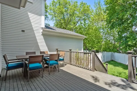 a view of a deck with two chairs and wooden floor