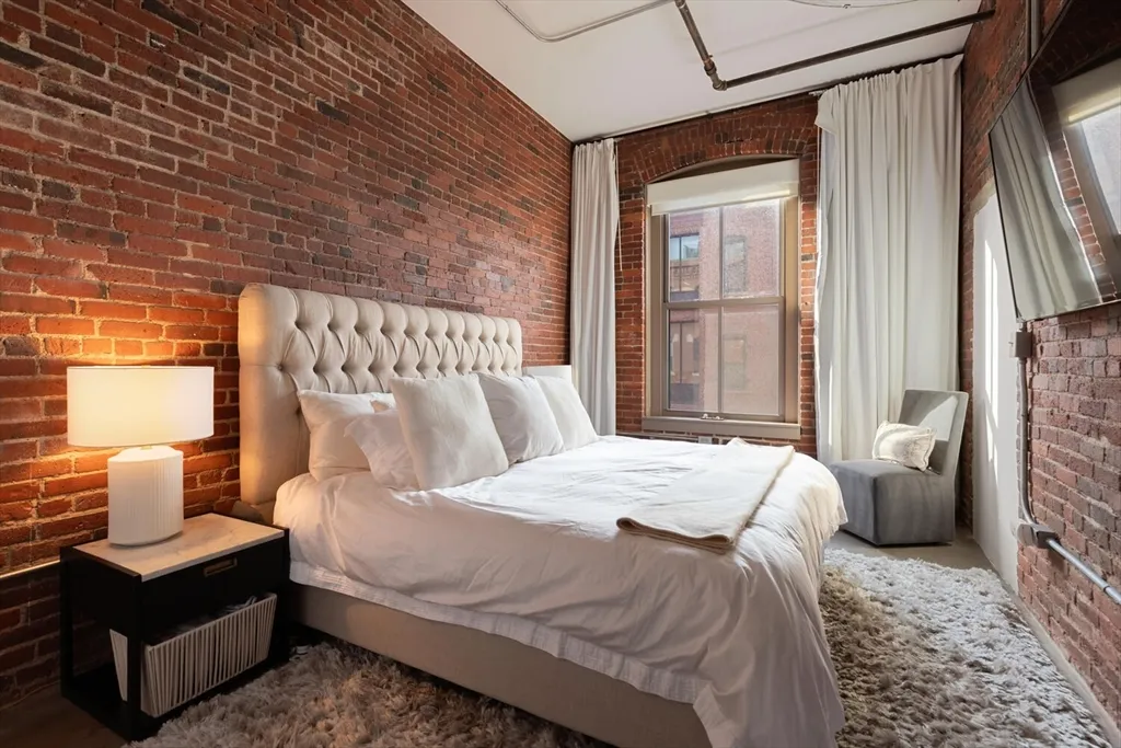 a bedroom with a bed wooden floor and window