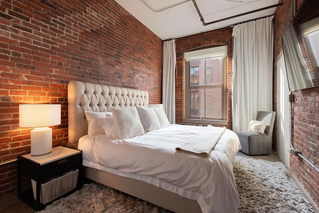 35 Channel Center Street, Unit 402 Boston, MA 02210 - Photo 19 of 35 a bedroom with a bed wooden floor and window