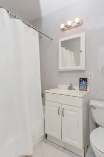 a bathroom with a sink vanity mirror and toilet