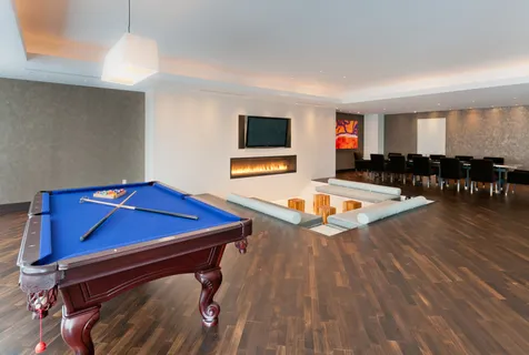 a living room with furniture pool table and a window