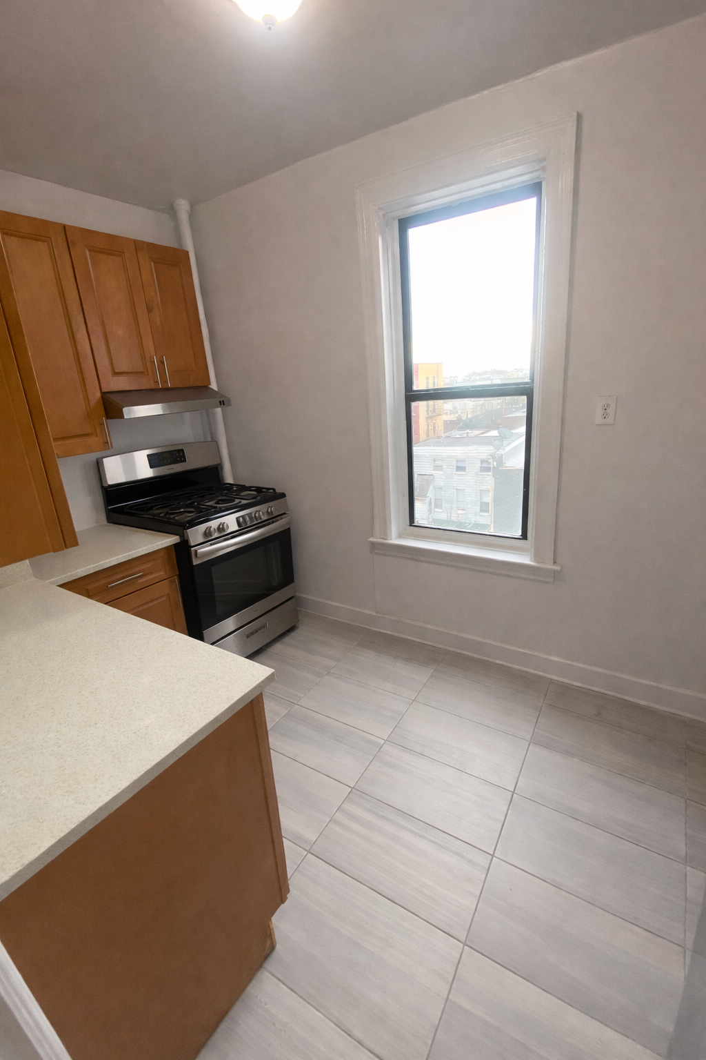 28-23 42nd Street, Unit D5 Queens, NY 11103 - Photo 3 of 10 a kitchen with a stove and a cabinet