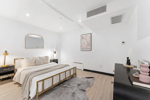 a bedroom with a bed and wooden floor