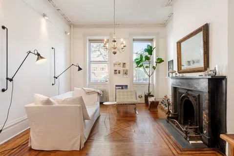 a living room with furniture a fireplace and a chandelier