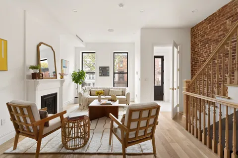 a living room with furniture a fireplace and a potted plant
