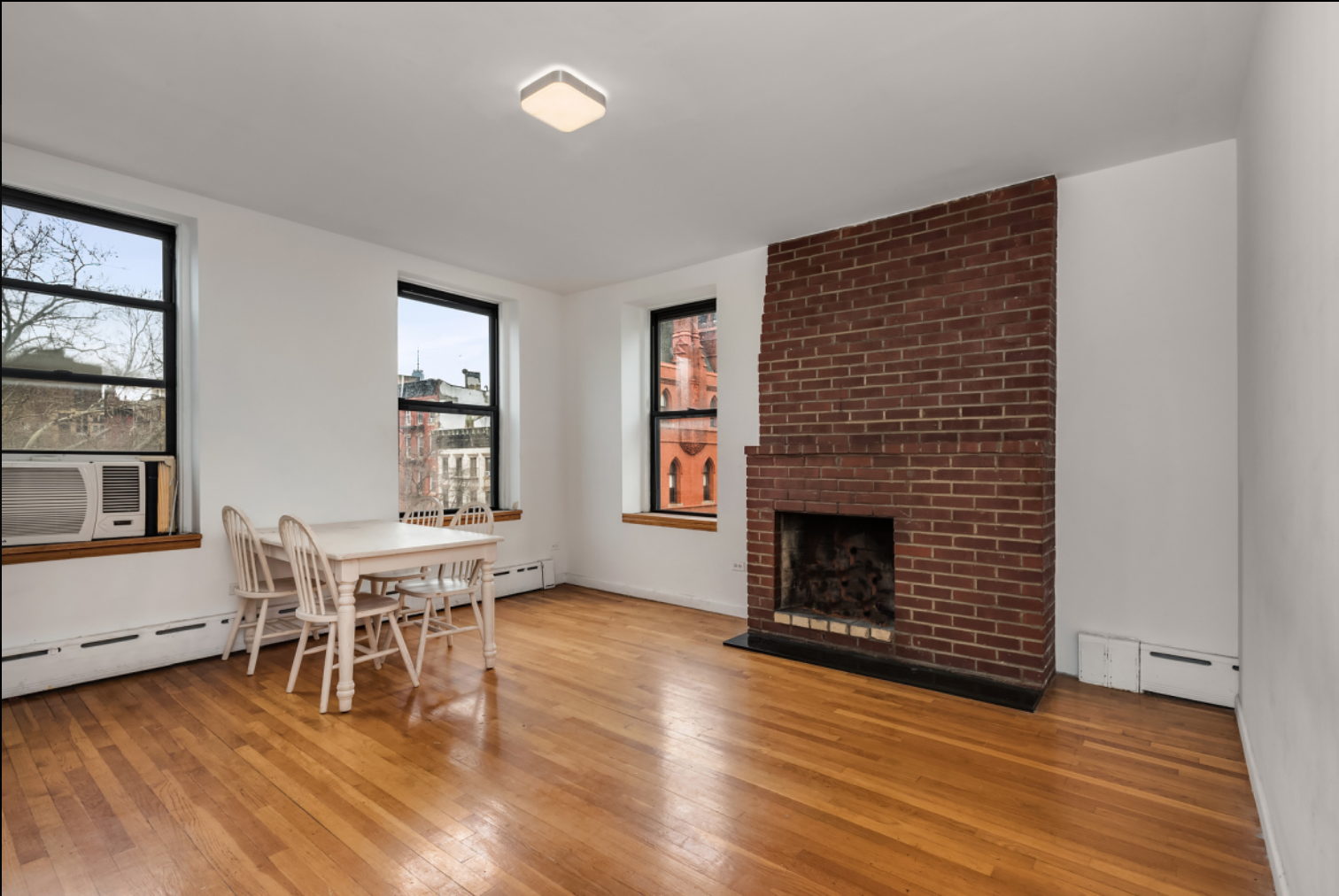 293 East 10th Street, Unit 4 Manhattan, NY 10009 - Photo 4 of 8 a living room with furniture and a fireplace