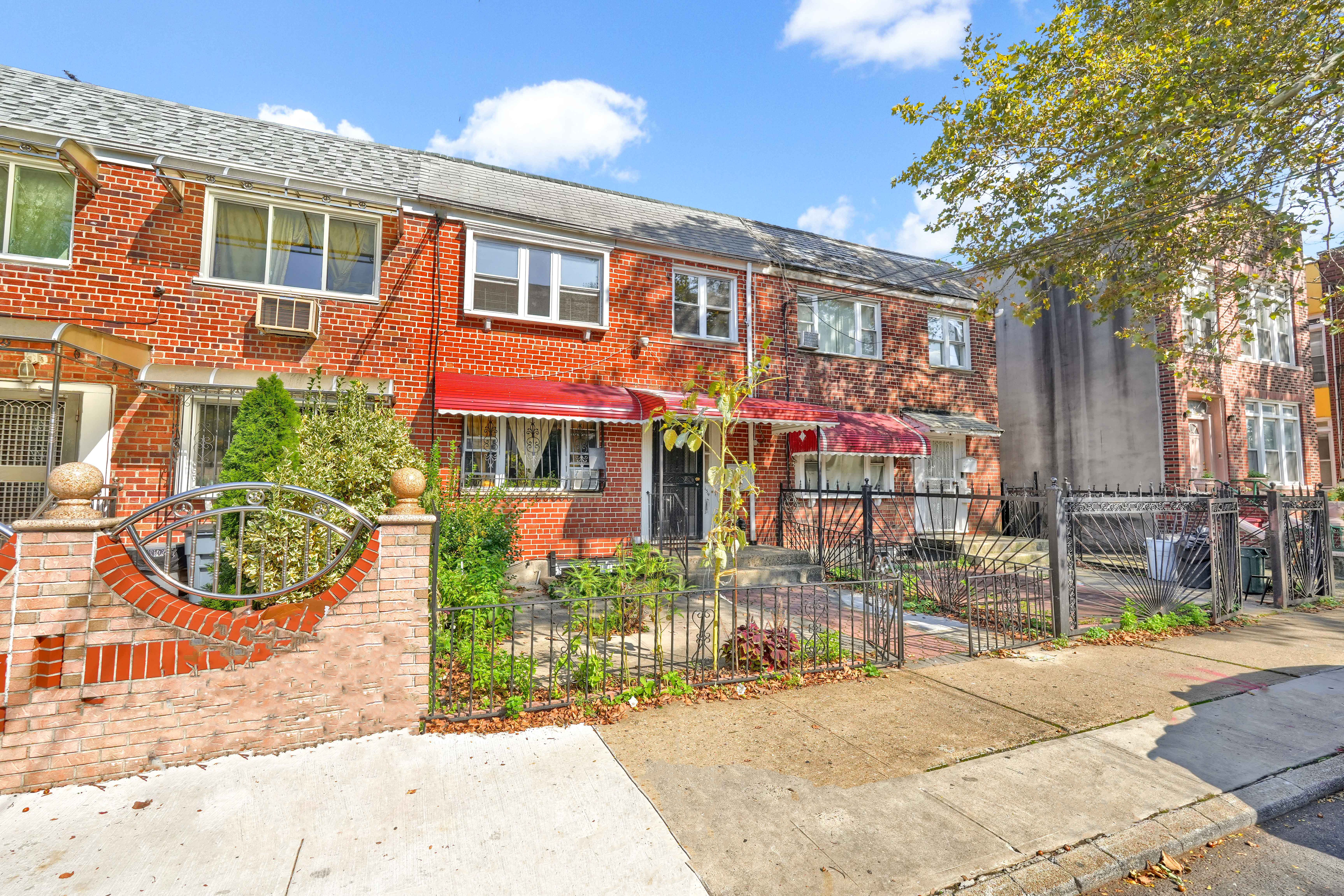 659 Jerome Street Brooklyn, NY 11207 - Photo 34 of 39 a front view of a building with a garden and plants