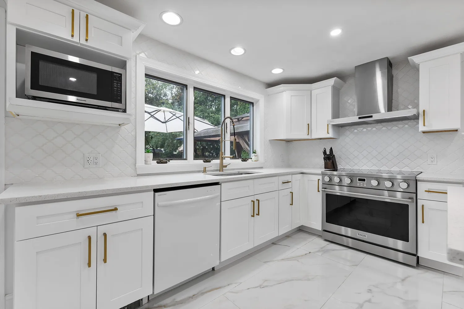 a kitchen with granite countertop a sink stainless steel appliances and cabinets