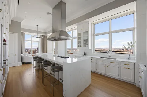 a kitchen with center island wooden floor and a large window