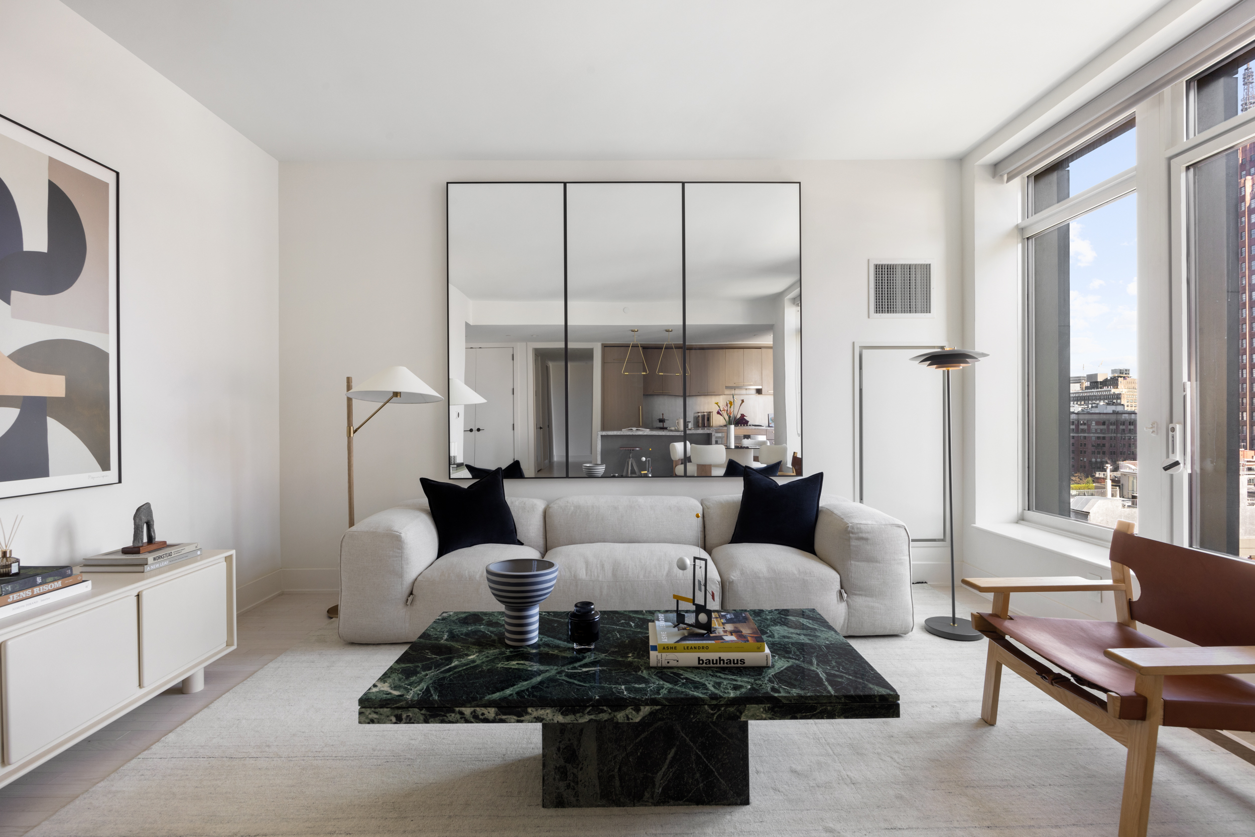 91 Leonard Street, Unit 11G Manhattan, NY 10013 - Photo 3 of 16 a living room with furniture a large window and a dining table