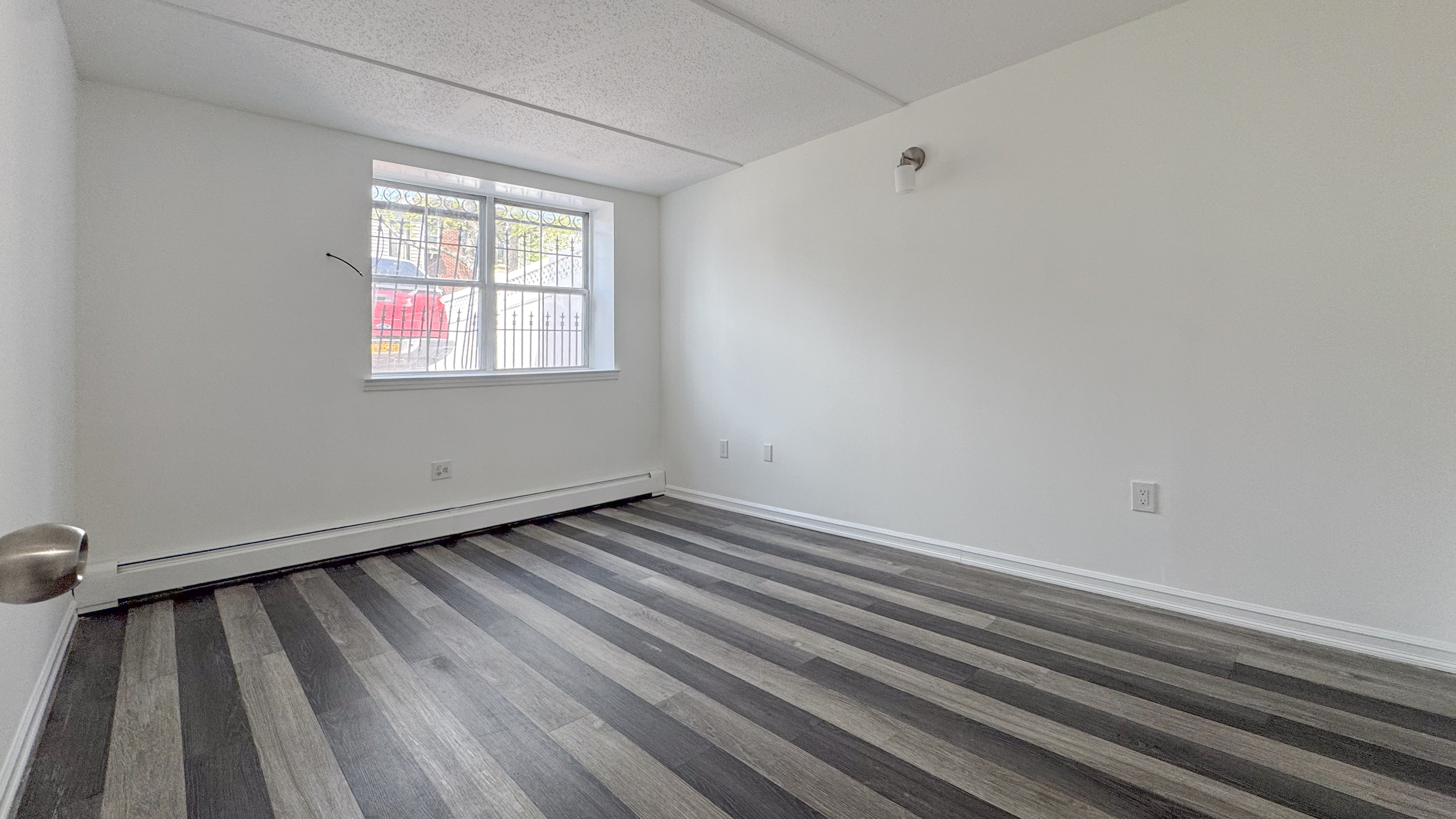 175 Eldert Street, Unit 1 Brooklyn, NY 11207 - Photo 6 of 12 a view of a room with wooden floor and windows