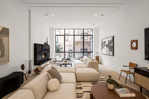 a living room with furniture large window and a flat screen tv