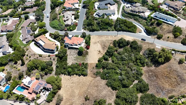 an aerial view of a house with a yard and lake view