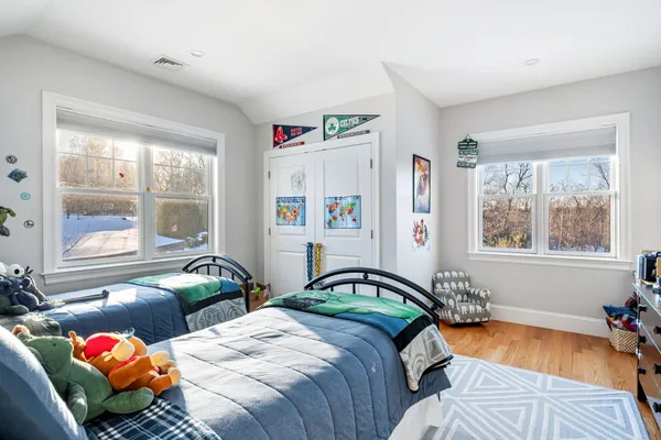 a bedroom with two beds next to a window