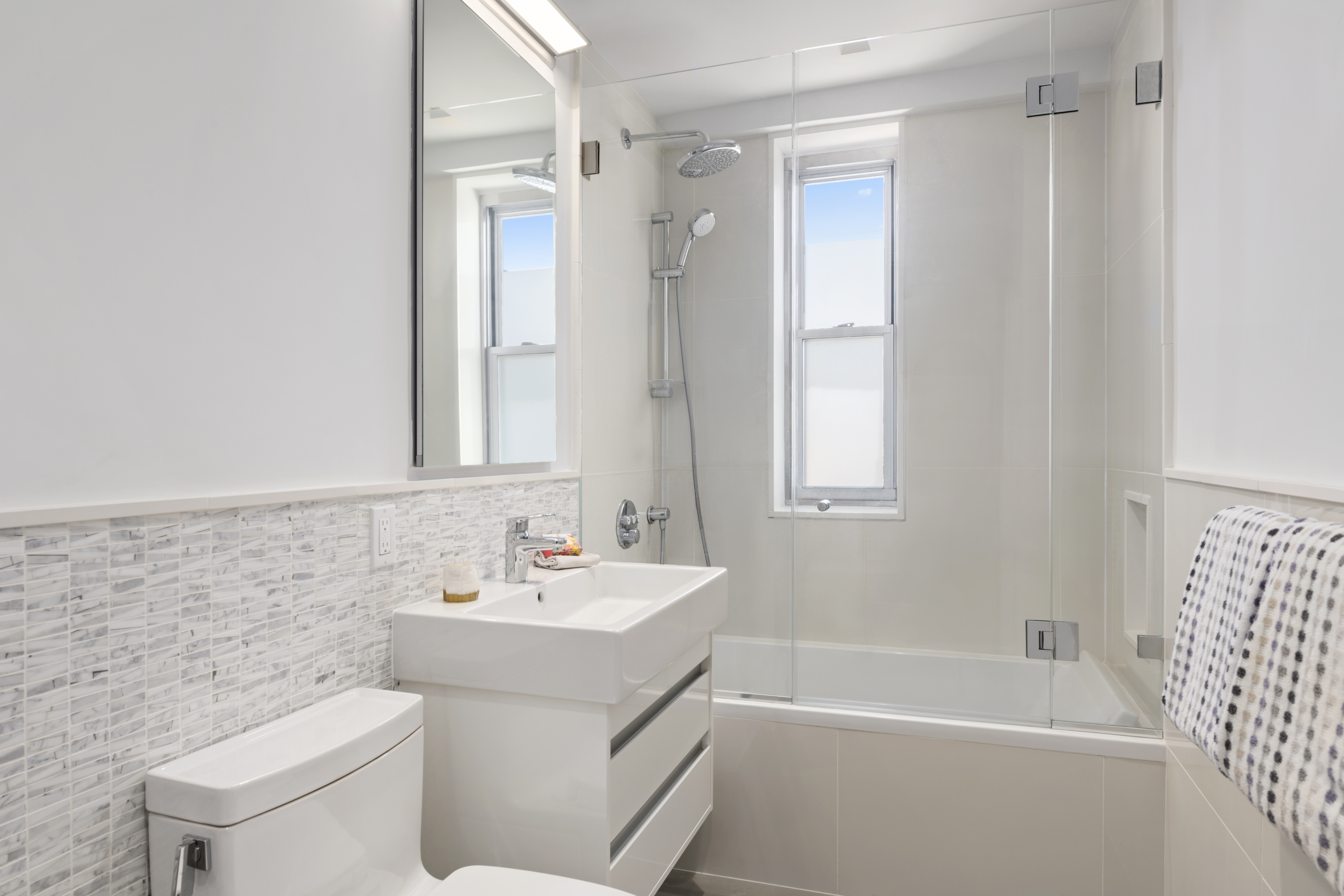 573 Grand Street, Unit D1707/1801 Manhattan, NY 10002 - Photo 18 of 24 a bathroom with a sink toilet and shower