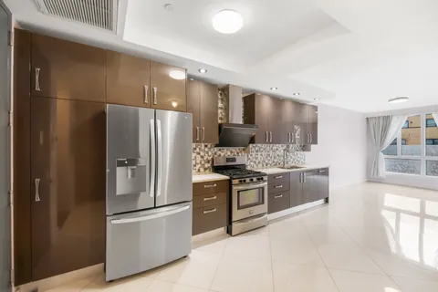 a kitchen with stainless steel appliances kitchen island granite countertop a refrigerator and a stove