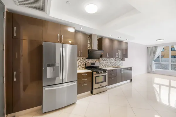 a kitchen with stainless steel appliances kitchen island granite countertop a refrigerator and a stove